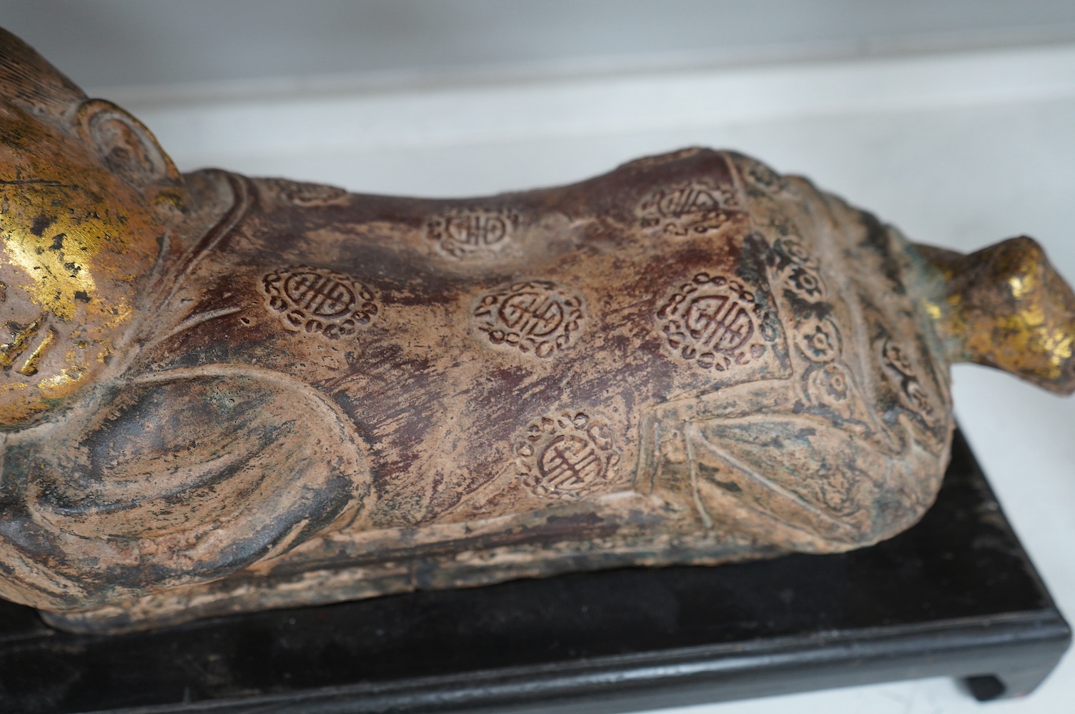 Two Chinese polychrome decorated iron pillows, modelled as sleeping children, on ebonised wood plinths, 44cm long. Condition - fair to good